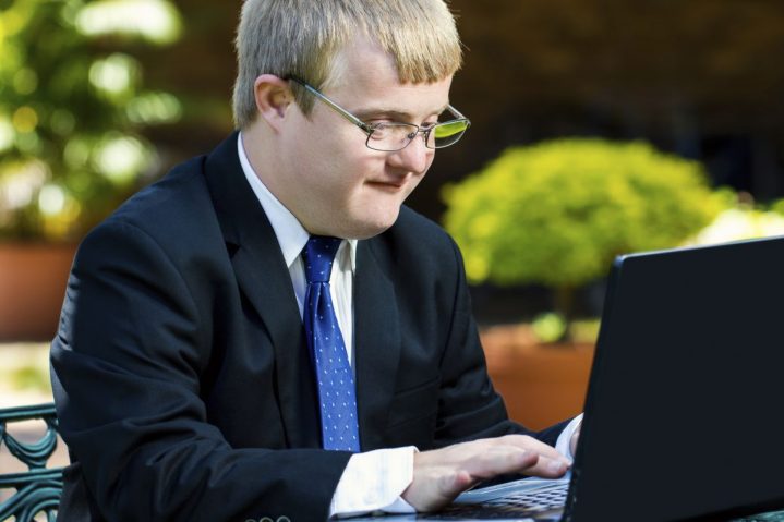 young businessman with Developmental Disabilities working on laptop